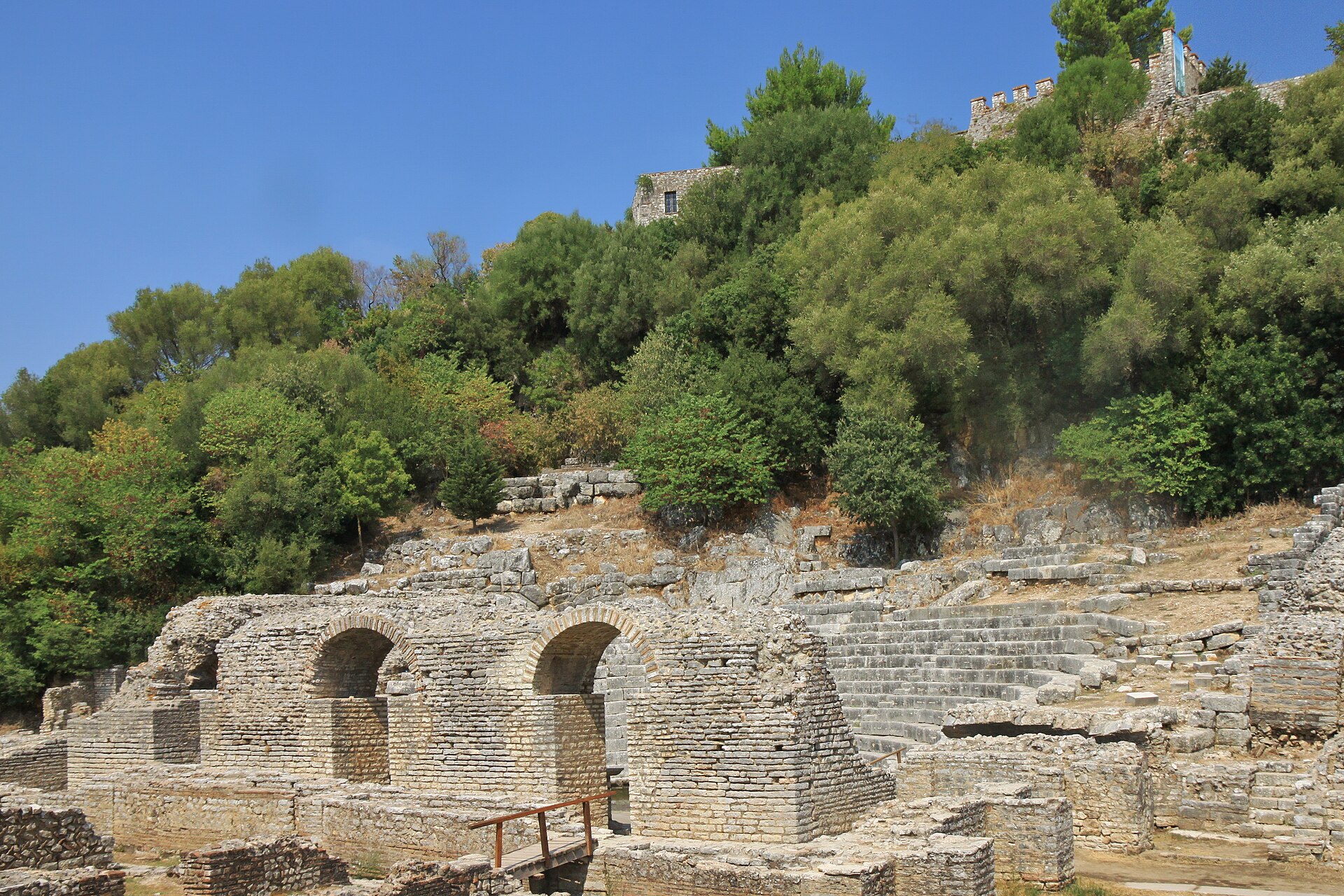 Butrint's ancient theatre, with the castle walls above the trees